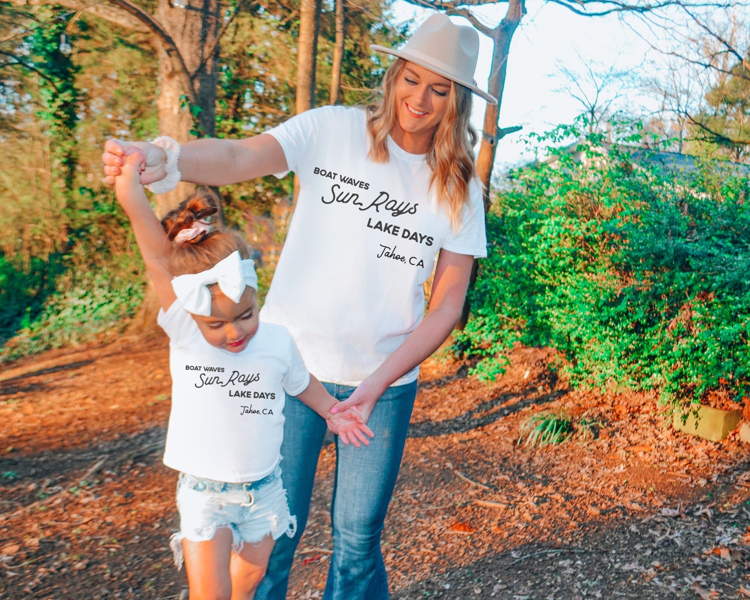 mother and daughter wearing custom matching family lake vacation tshirt with boat waves sun rays lake days on shite shirt