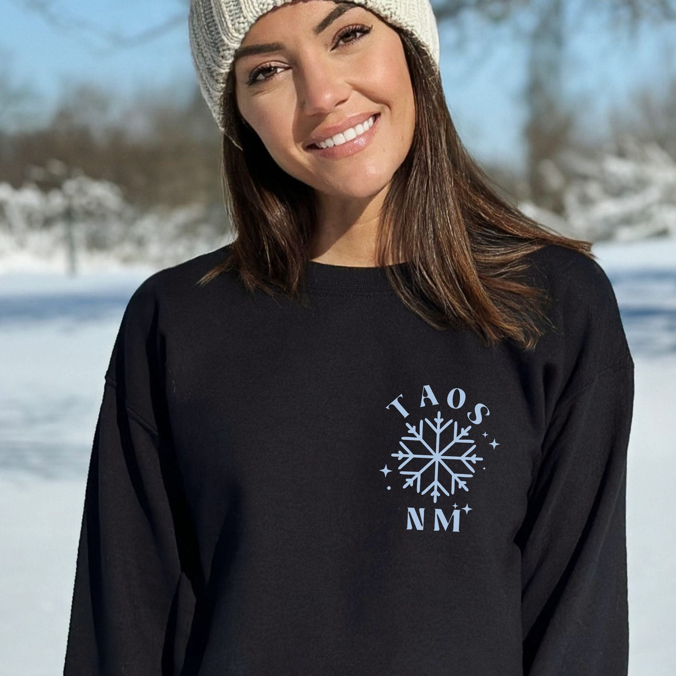 Woman wearing custom matching group girls ski trip sweatshirt with powder and poles design on black crewneck