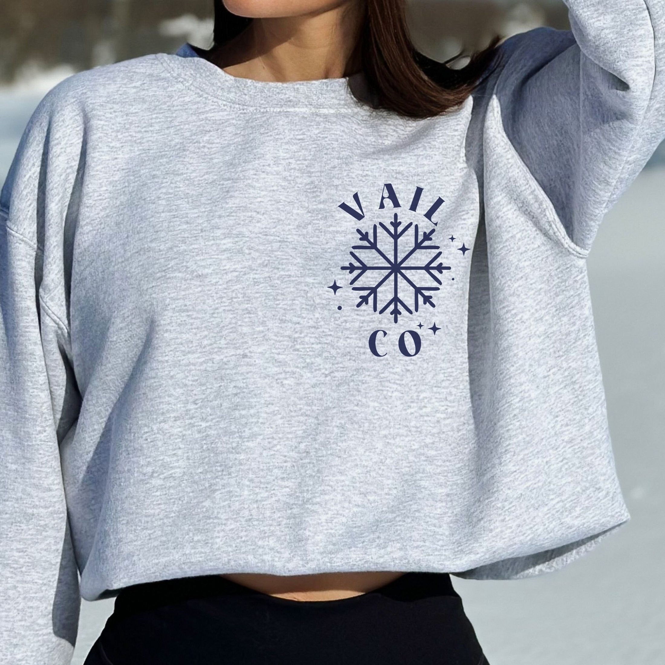 Woman wearing custom matching group girls ski trip sweatshirt with powder and poles design on ash crewneck