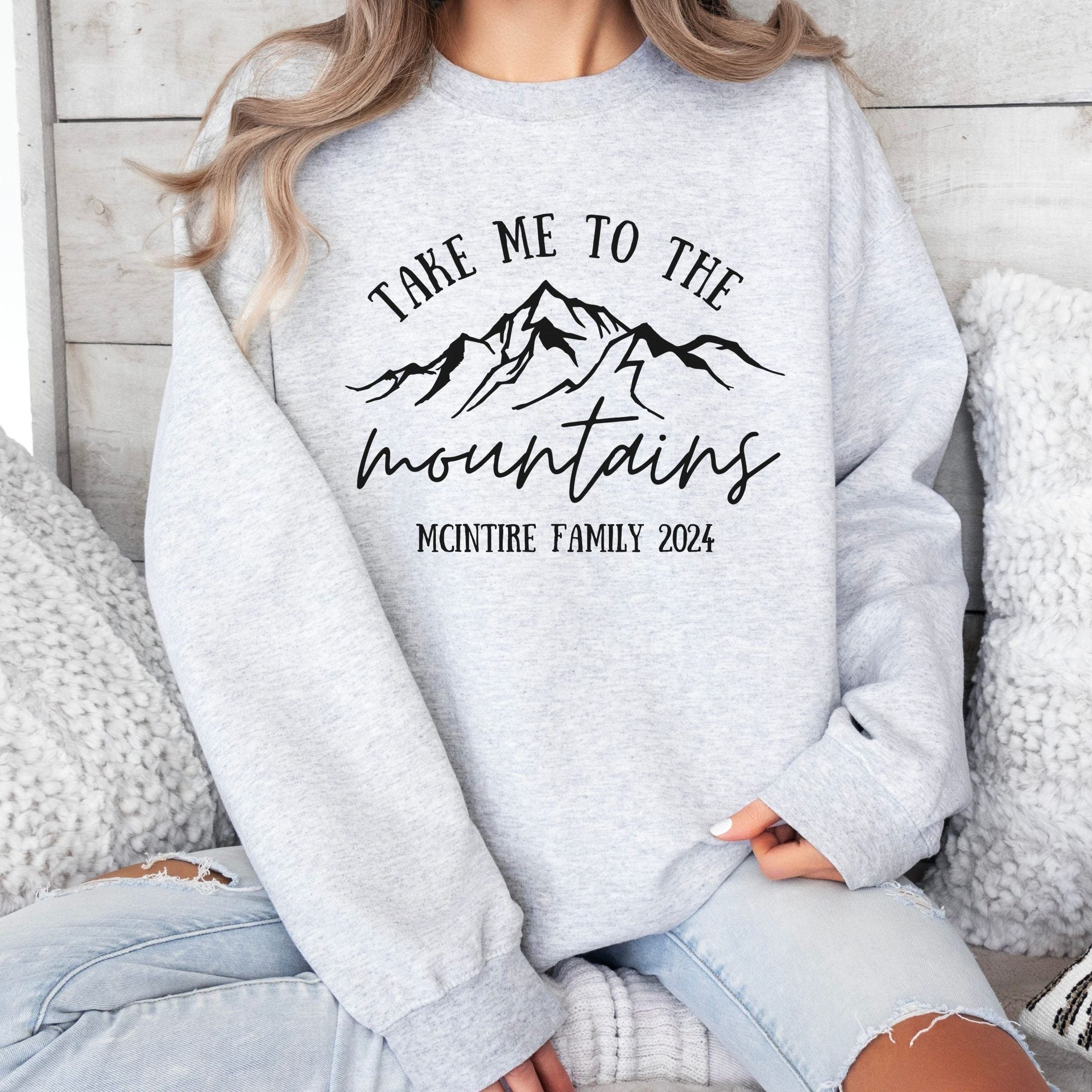 woman wearing custom matching family vacation take me to the mountains shirt for group ski weekend trips. shown in ash crewneck sweatshirt