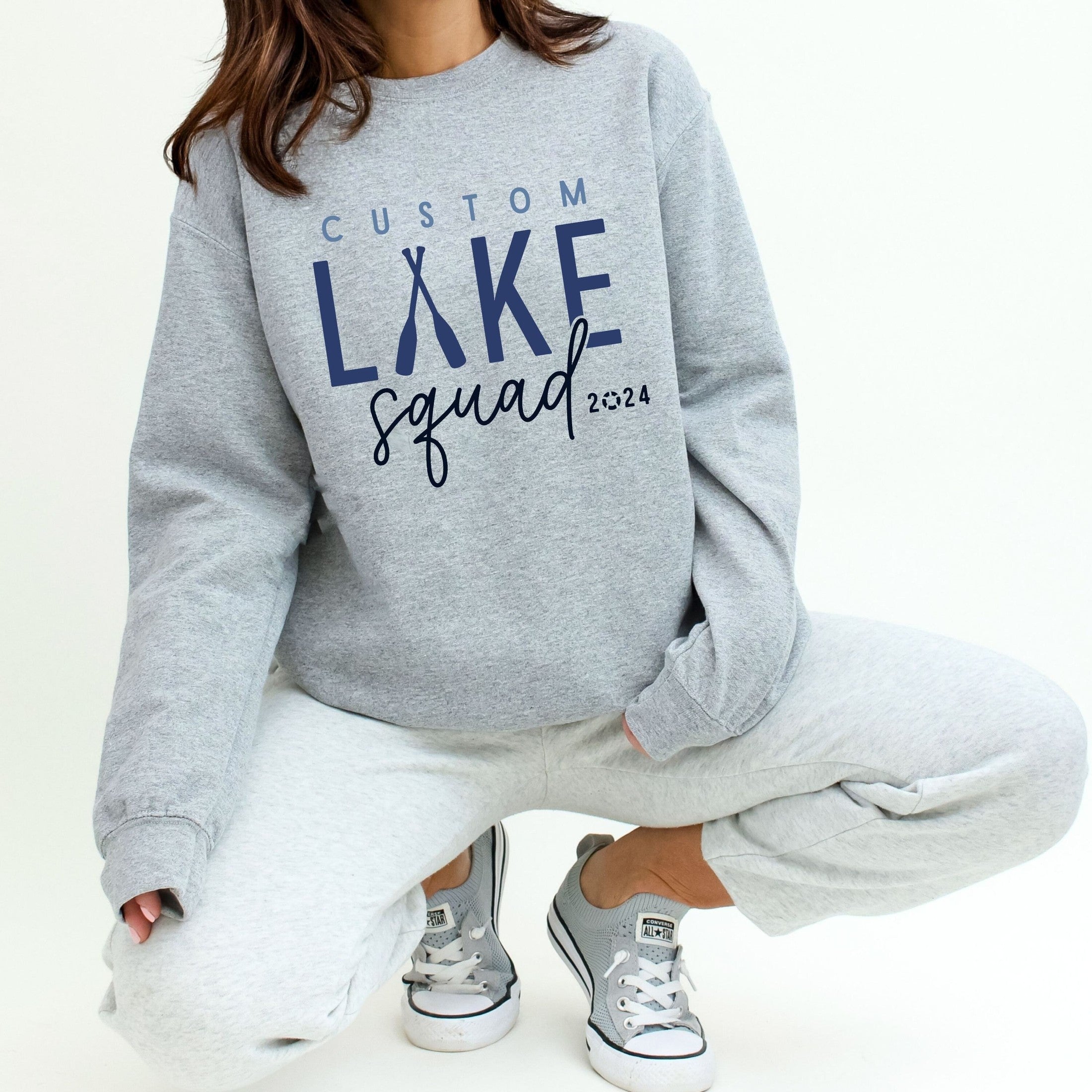 woman wearing custom matching family Lake Squad shirts personalized with name and year. Perfect for group lake vacations, shown in gray crewneck sweatshirt