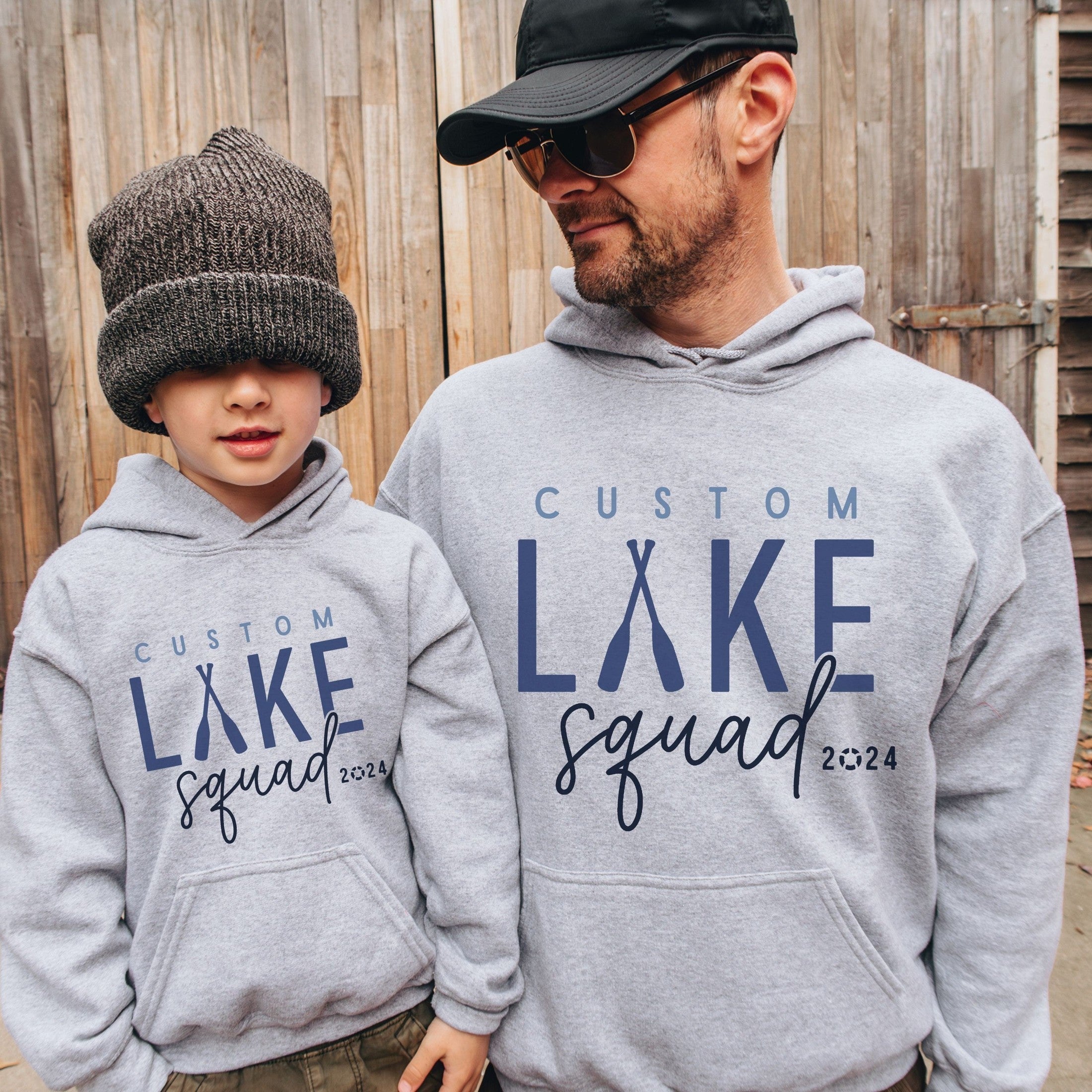 Man and boy wearing custom matching family Lake Squad shirts personalized with name and year. Perfect for group lake vacations, shown in gray hoodies