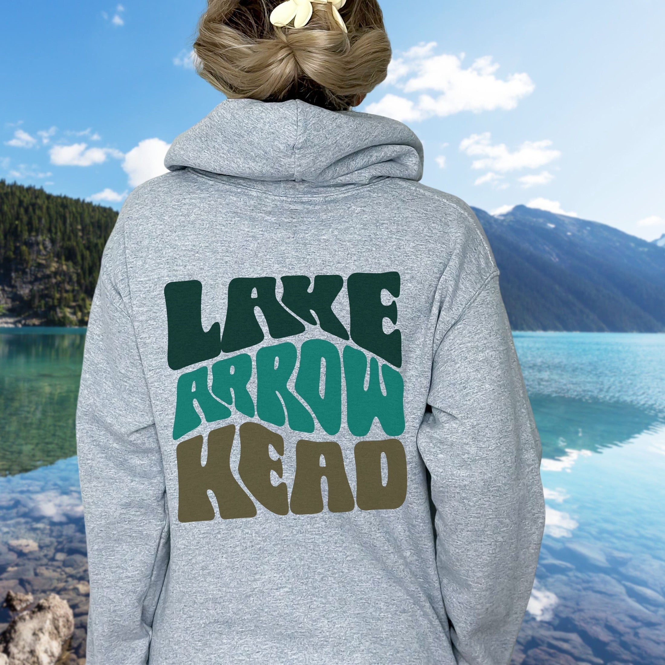 woman wearing custom matching family adventure vacation shirt with green retro style Happy Camper design. Perfect for group camping trips. Shown on gray hoodie