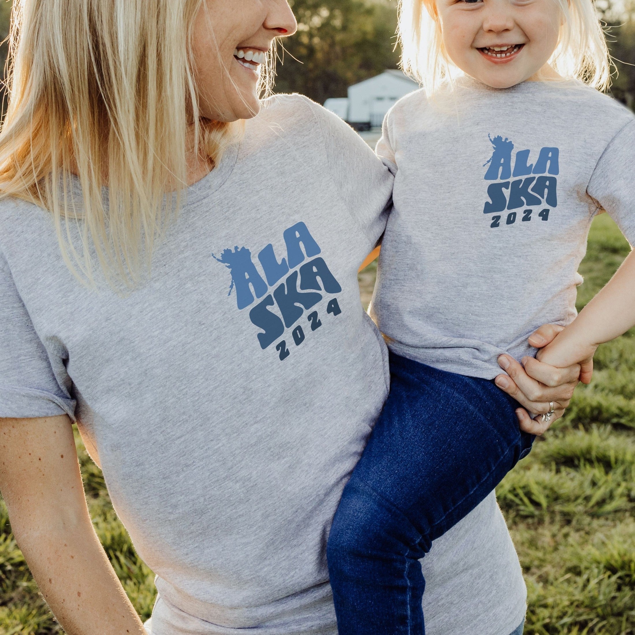 woman and toddler wearing custom matching family Alaska cruise shirt for group Alaskan vacation. Shown in gray tshirts