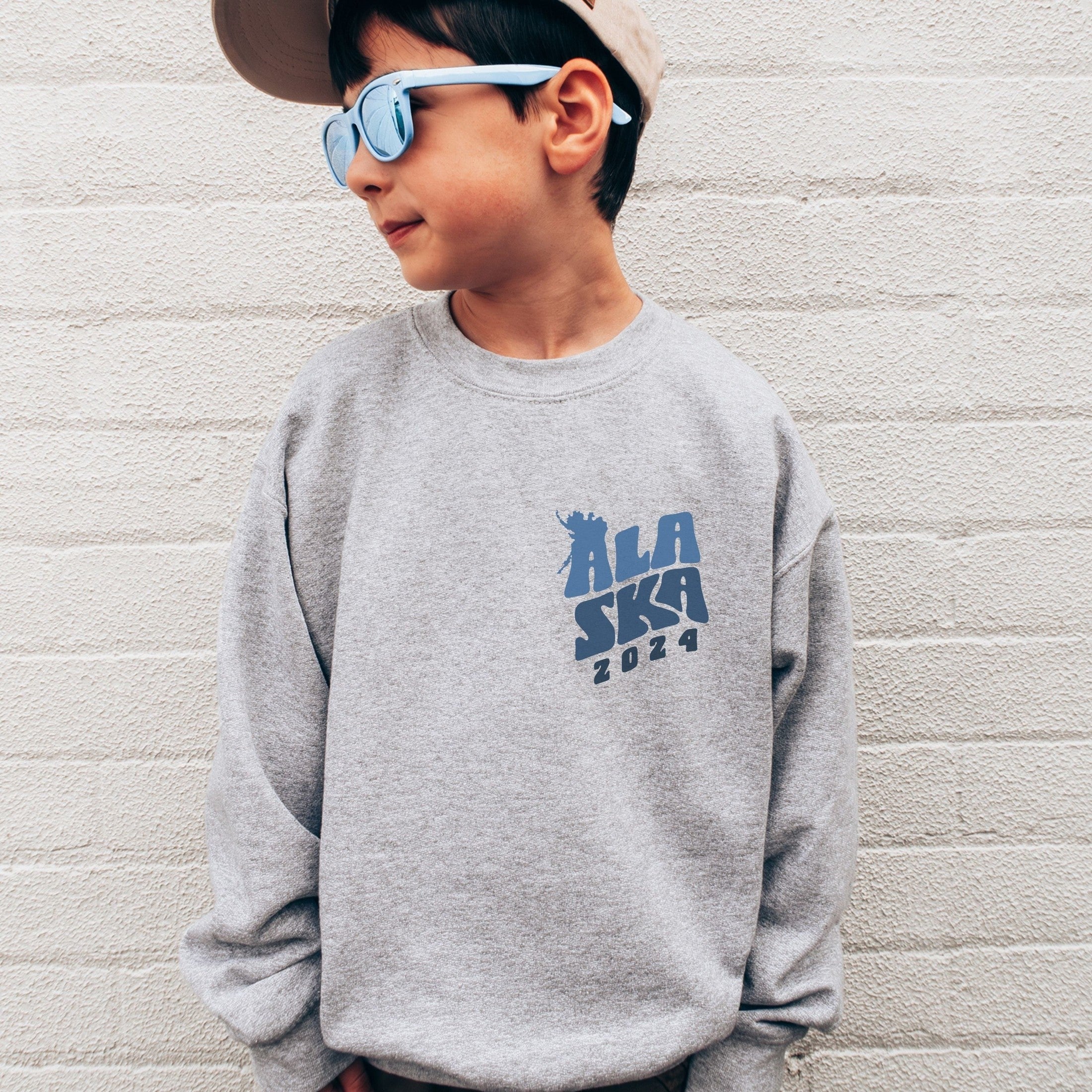 boy wearing custom matching family Alaska cruise shirt for group Alaskan vacation. Shown in gray crewneck sweatshirt