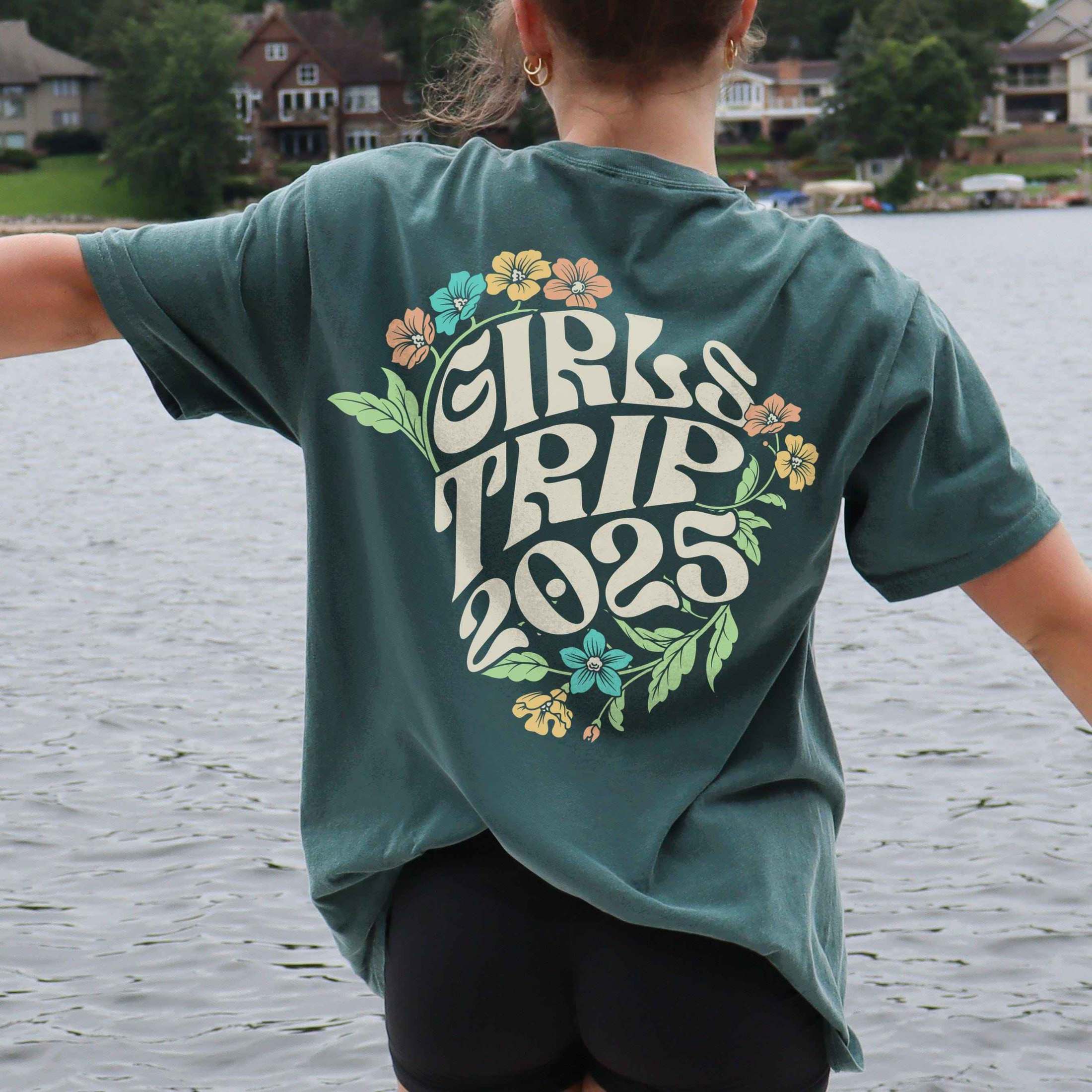 Woman wearing custom matching 60s or 70s retro floral girls trip shirts for group vacation shown in Comfort Colors Blue Spruce