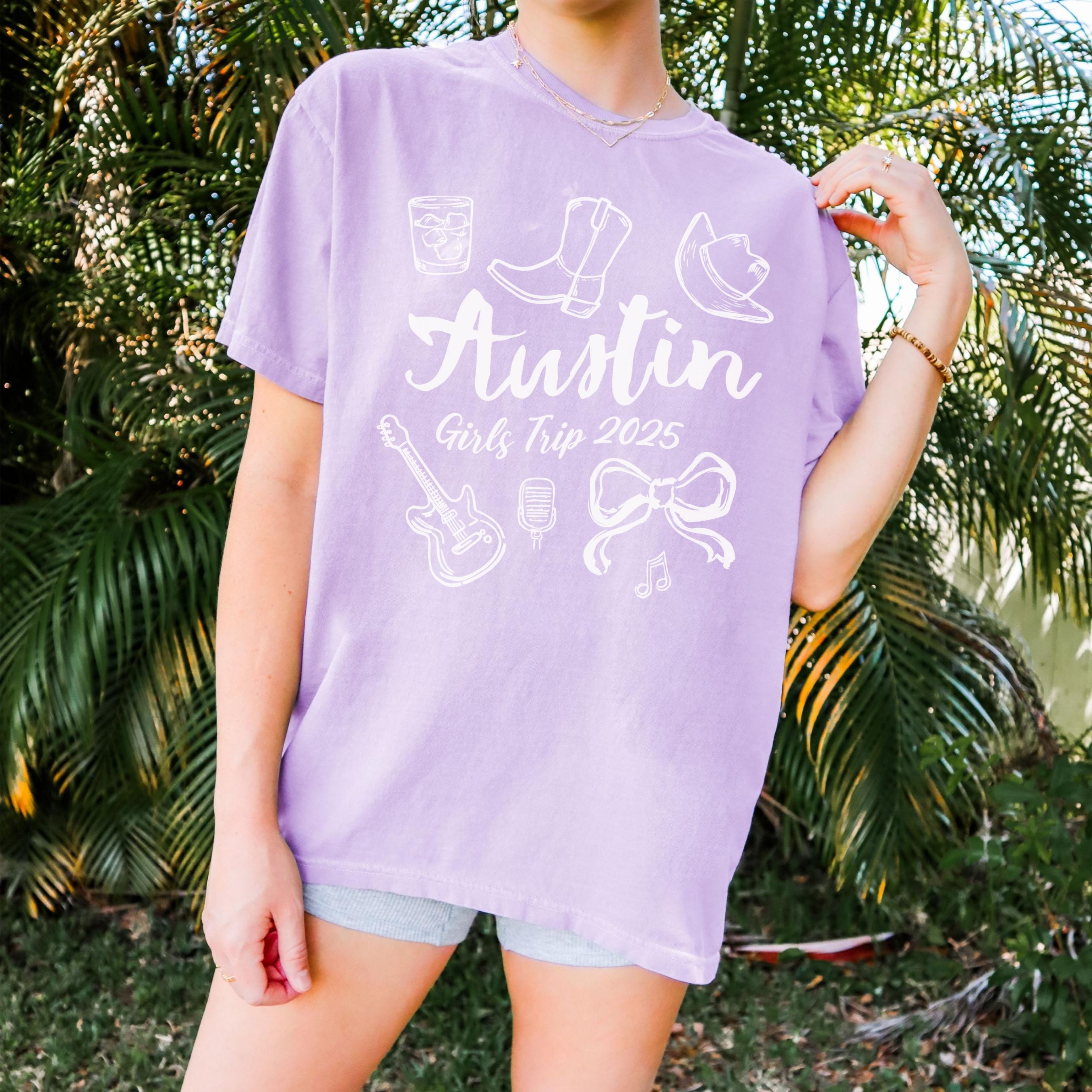 Austin girls trip shirt with coquette bow and travel doodle design, printed on Comfort Colors Orchid for matching group vacations