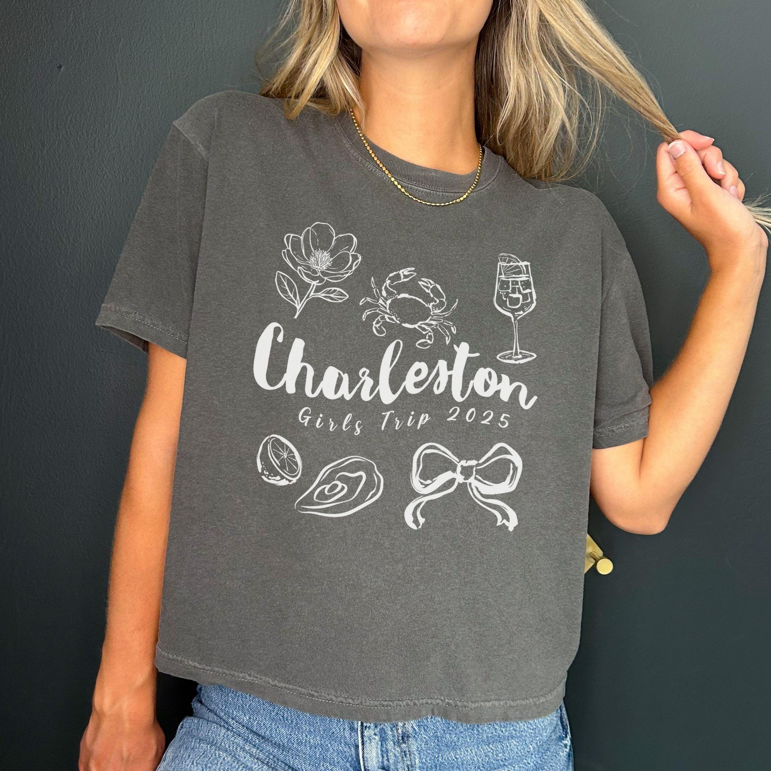 Charleston girls trip shirt with coquette bow and travel doodle design, printed on Comfort Colors Pepper boxy crop tee for matching group vacations