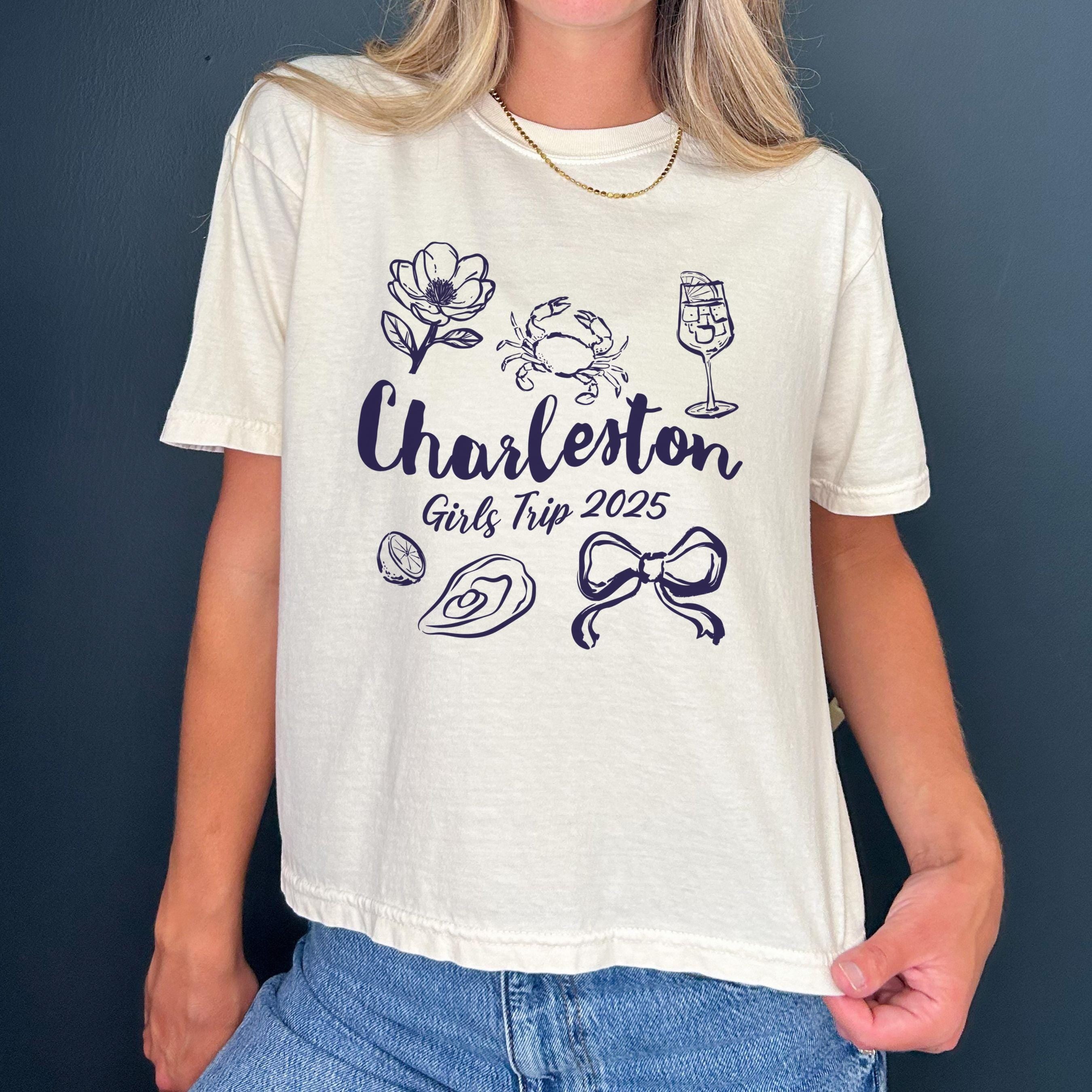 Charleston girls trip shirt with coquette bow and travel doodle design, printed on Comfort Colors Ivory boxy crop tee for matching group vacations