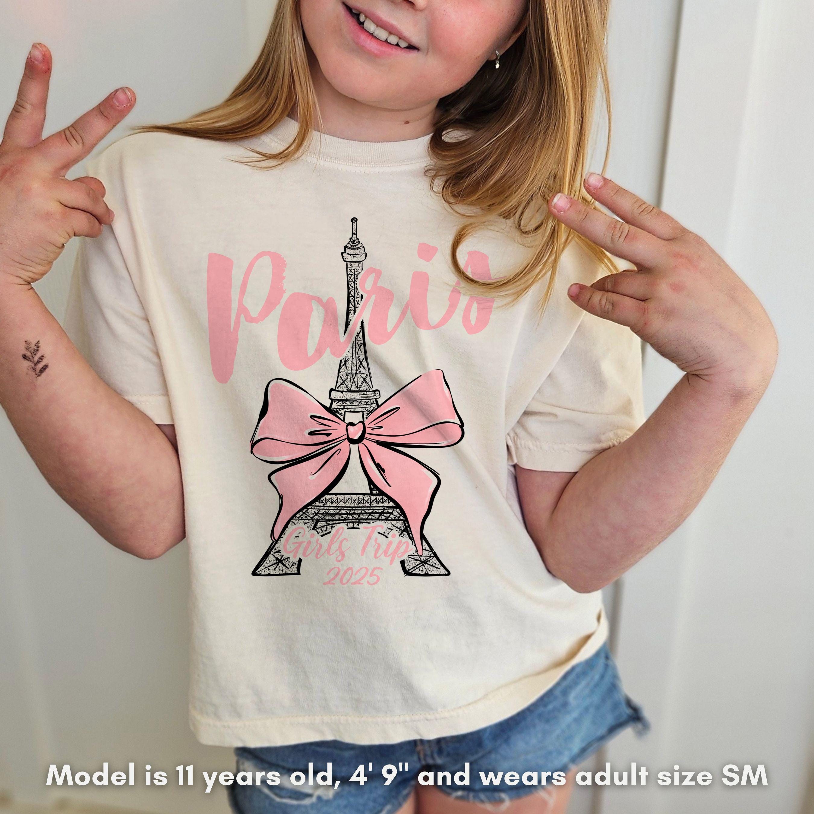 Custom Paris 2025 coquette-style t-shirt with Eiffel Tower and bow graphic, great for matching girls trip outfits