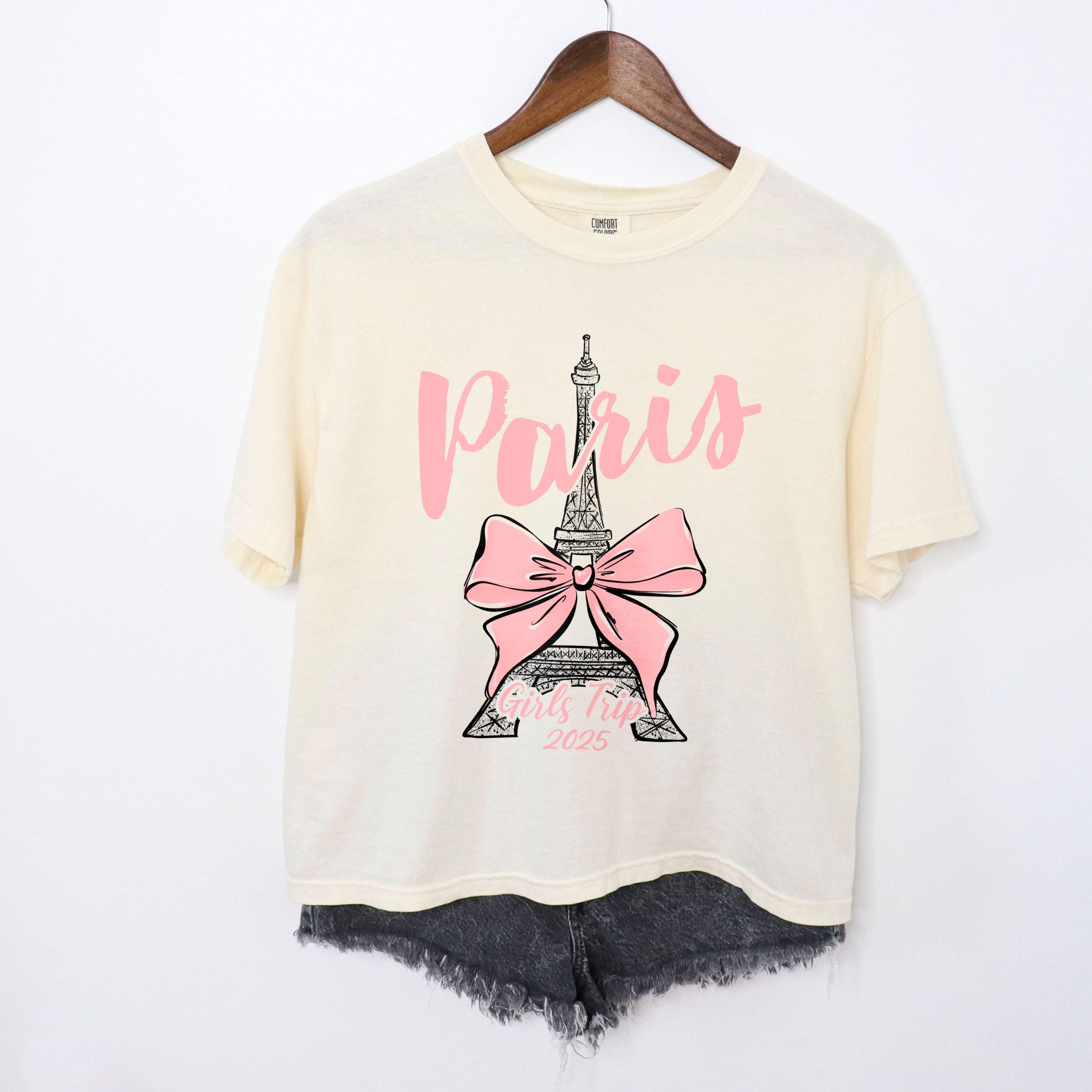 Custom Paris 2025 coquette-style t-shirt with Eiffel Tower and bow graphic, great for matching girls trip outfits