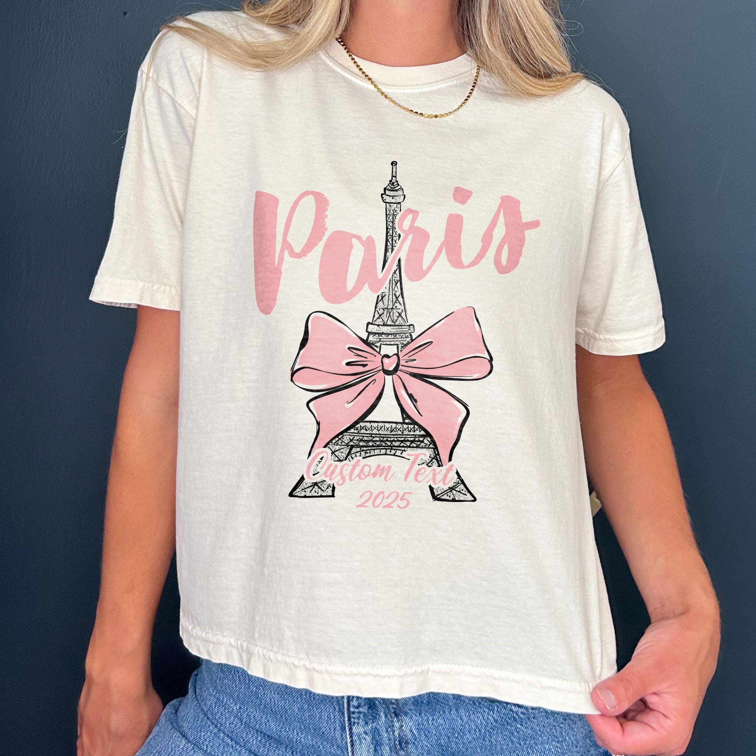 Custom Paris 2025 coquette-style t-shirt with Eiffel Tower and bow graphic, great for matching girls trip outfits