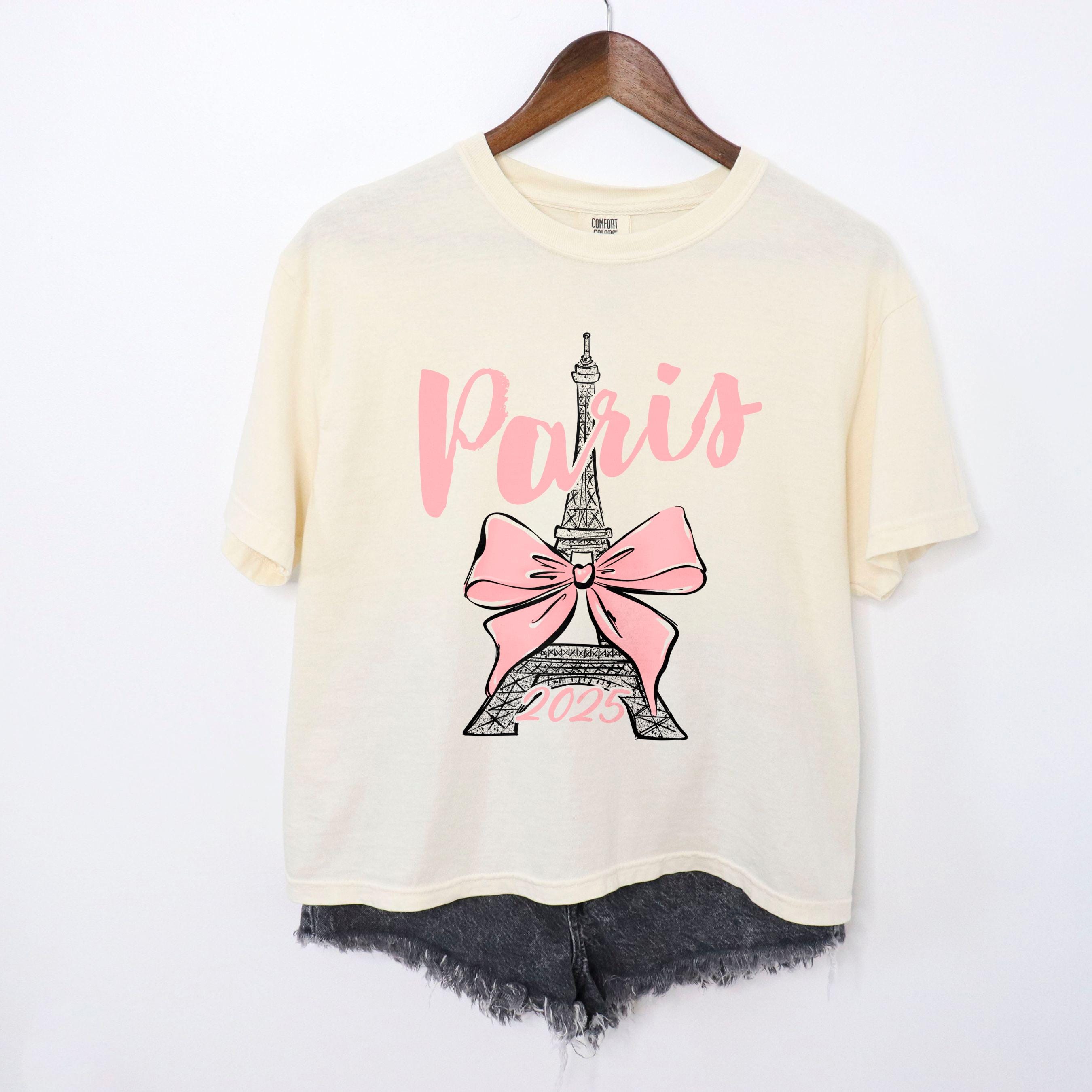 Custom Paris 2025 coquette-style t-shirt with Eiffel Tower and bow graphic, great for matching girls trip outfits