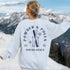 Woman wearing custom matching group girls ski trip sweatshirt with powder and poles design on ash crewneck