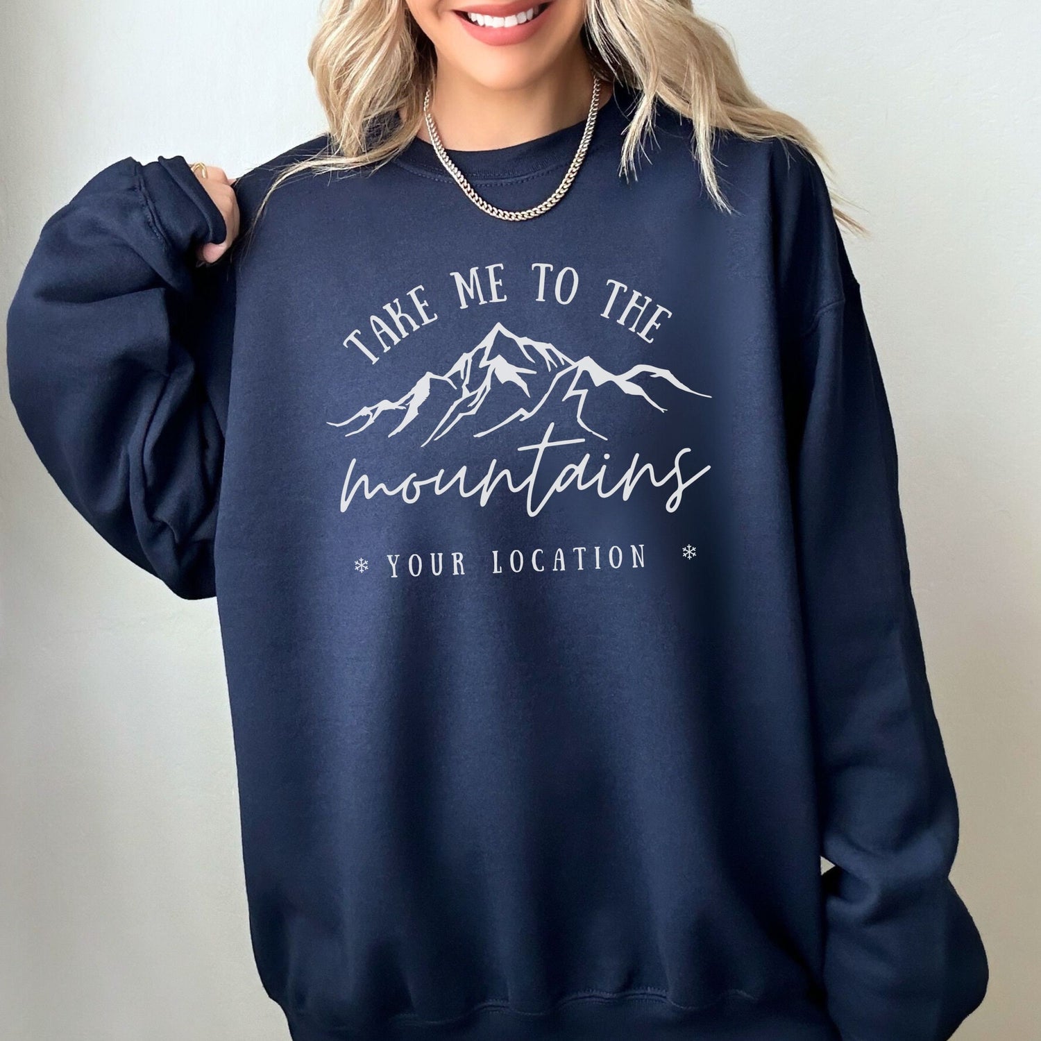 woman wearing custom matching family vacation take me to the mountains shirt for group ski weekend trips. shown in navy crewneck sweatshirt