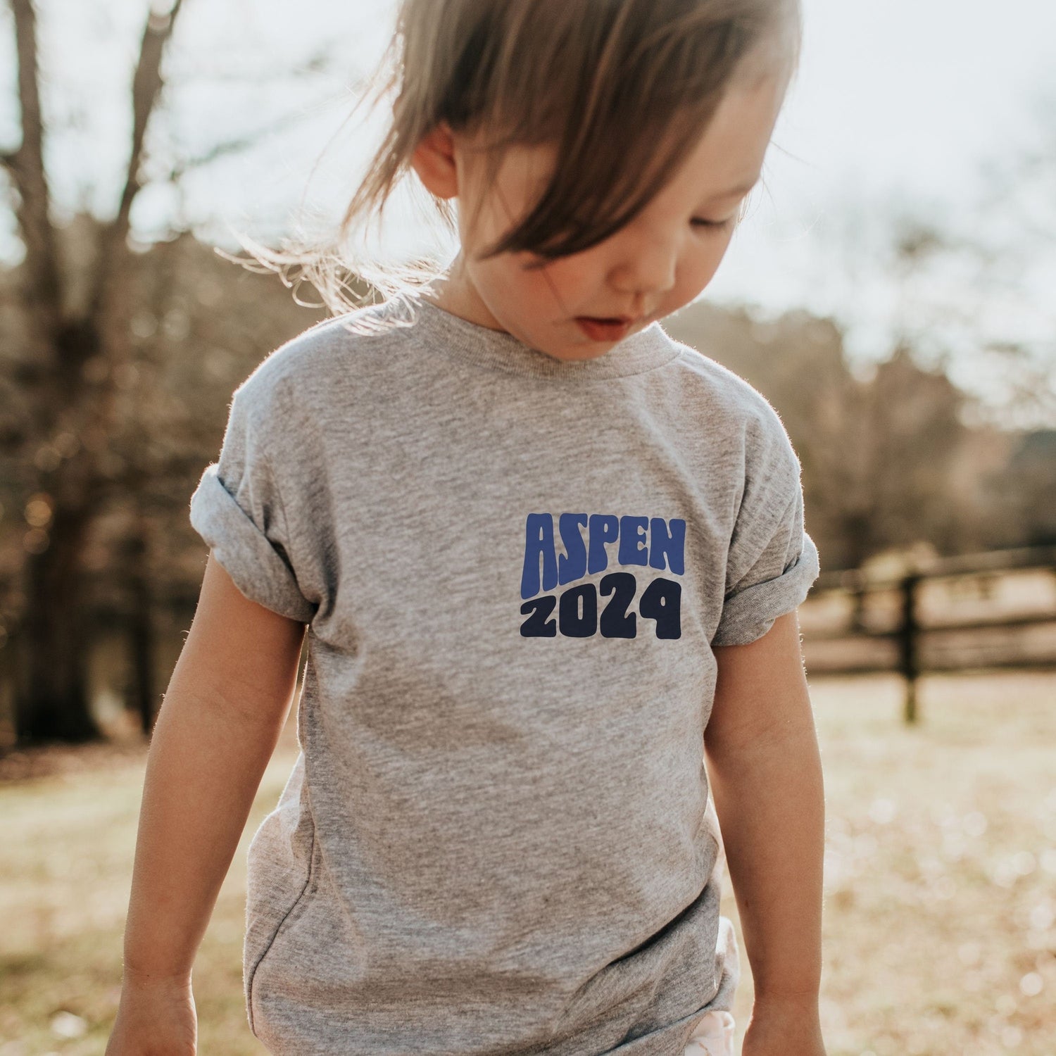 girl wearing custom matching family adventure vacation shirt with blue retro style Take Me To The Mountains design. Perfect for group ski weekends. Shown on gray tshirt