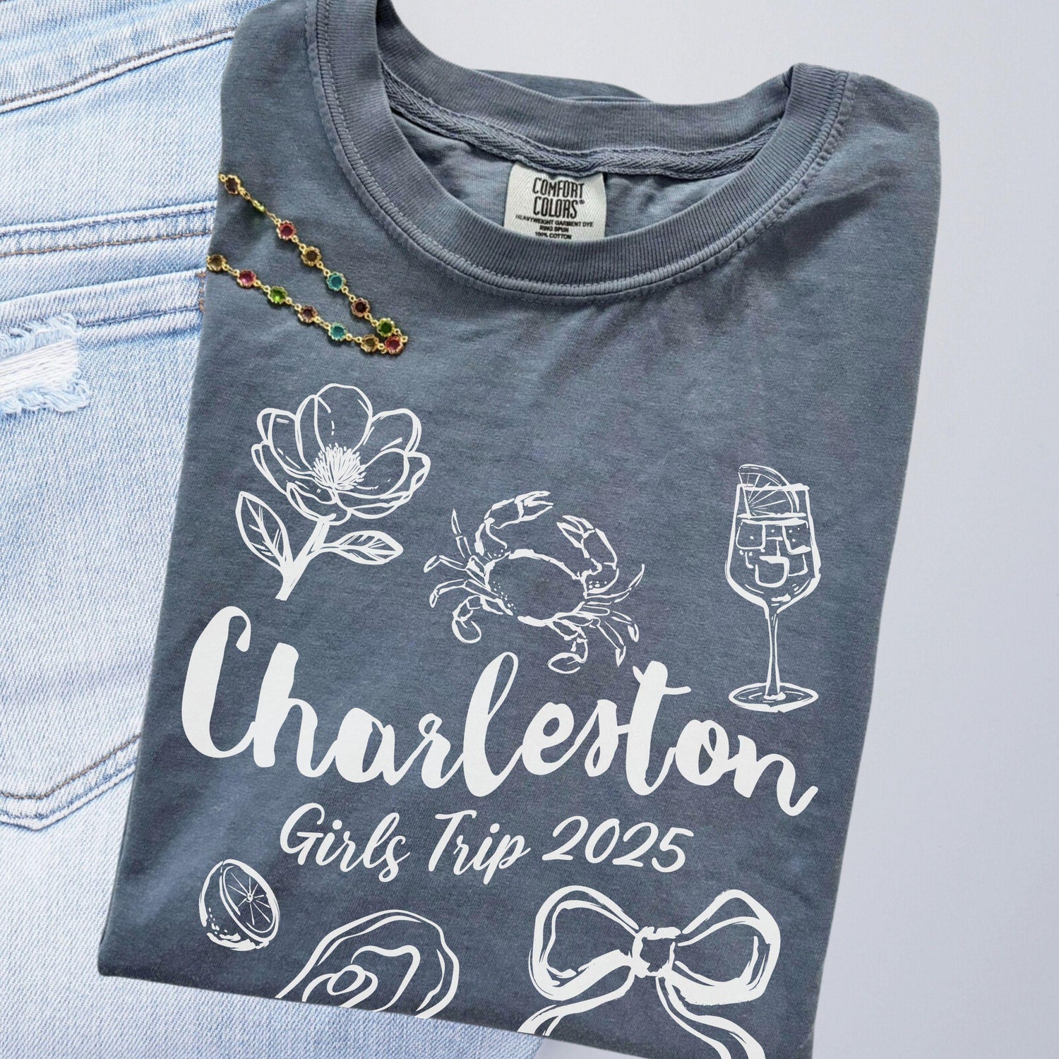 Charleston girls trip shirt with coquette bow and travel doodle design, printed on Comfort Colors Blue Jean for matching group vacations