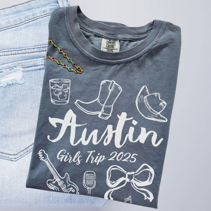 Austin girls trip shirt with coquette bow and travel doodle design, printed on Comfort Colors Blue Jean for matching group vacations