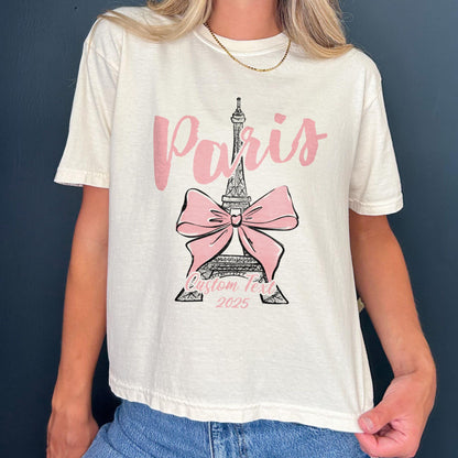 Custom Paris 2025 coquette-style t-shirt with Eiffel Tower and bow graphic, great for matching girls trip outfits